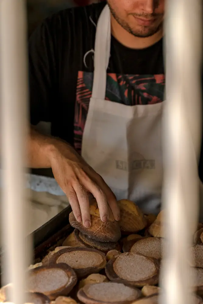 Panadero acomodando pan dulce en una charola